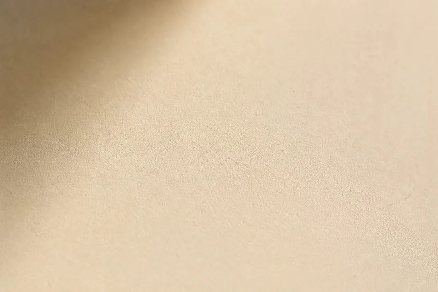 Warm beleuchtete, feinkoernige Papierflaeche